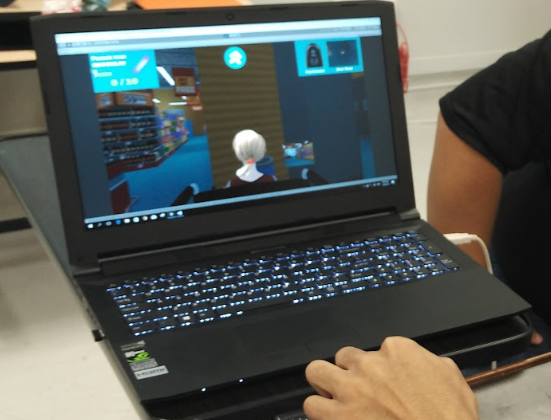 Client controlling the first person simulator via a joystick on his wheelchair. Client is controlling the character's movement in a public library scenario to develop his situational awareness.